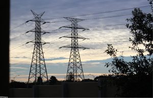 Zdjęcie ilustracyjne do informacji o otrzymanym wsparciu unijnym na rozwój sieci elektroenergetycznych. Na zdjęciu dwa słupy elektryczne.